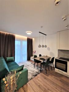 维尔纽斯Aurea apartment的客厅配有绿色沙发和桌子