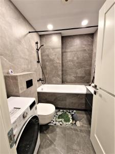维尔纽斯Aurea apartment的浴室配有卫生间、盥洗盆和洗衣机。