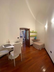热那亚LE MURA的一间带桌子和白色椅子的用餐室