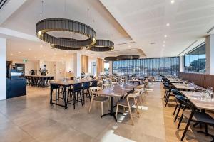 珀斯Ingot Hotel Perth, Ascend Hotel Collection的用餐室设有桌椅和窗户。