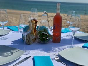 艾福雷诺德精品城堡公寓式酒店的海滩上一张桌子、眼镜和一瓶葡萄酒