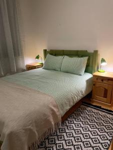 VukovinaSunny Hill kuća za odmor na Zlataru的一间卧室配有一张带2个床头柜和2盏灯的床。