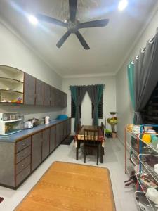 CukaiRK ASIANA HOMESTAY, KEMAMAN的厨房配有吊扇和桌子