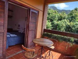 乌巴图巴Solar das Canoas Prumirim的阳台配有小桌子和椅子,提供床铺