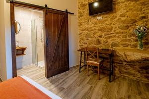 RianjoCasa Rural Laxido的一间卧室配有一张床、一张书桌和淋浴