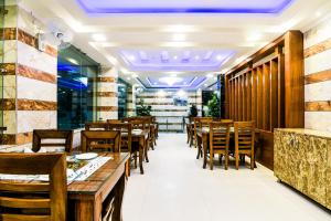 新德里Hotel Pearl - Mahipalpur Delhi Airport的用餐室配有木桌和椅子