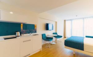 巴统Batumi Next Sea Aparthotel的一间卧室配有一张床、一间厨房和一张桌子
