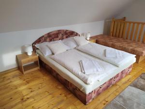 斯祖贝莱克Apartmány Orava - Zuberec的一张大床,位于带2个床头柜的房间