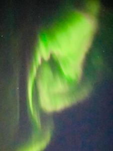 波多Idyllisk sjøhus på Naurstad的天空中北极光的图像