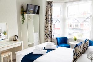 斯卡伯勒Kingsway Guesthouse - A selection of Single, Double and Family Rooms in a Central Location的一间卧室配有两张床和一张蓝色椅子