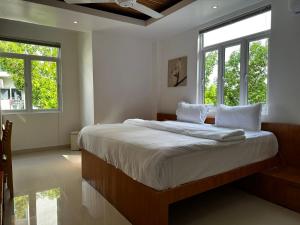 胡鲁马累PINE LODGE MALDIVES的卧室配有一张带白色床单和窗户的大床。