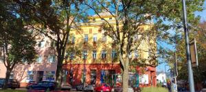 俄斯特拉发Apartment Belvedere的一座黄色的建筑,前面有汽车停放
