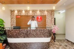 孟买Hotel Avion Park - Near Mumbai International Airport的大堂里的一个男人在说手机