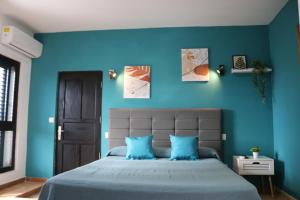 阿雷西费Apartamentos La Carmen的一间卧室拥有蓝色的墙壁,配有一张带蓝色枕头的床。