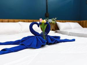 班敦孟Airport Mini Hostel at Don Muang Airport的床上的蓝色毯子,花瓶