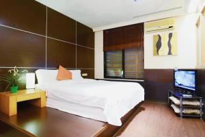 乌来乌来汤馆温泉会馆的卧室配有白色的床和电视。