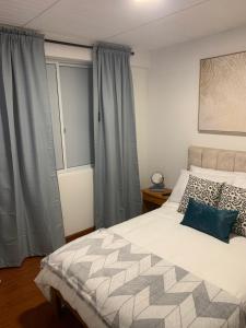 波哥大Confortable Apartaestudio的一间卧室设有一张大床和一个窗户。