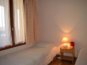 圣普里安海滩Appartement Saint-Cyprien, 2 pièces, 4 personnes - FR-1-225D-169的一间卧室设有两张床和一张桌子上的台灯。
