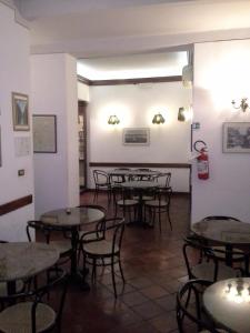 波吉邦西Albergo Italia di Nardi Renzo & C Snc的用餐室配有桌椅和灯光