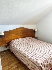 艾尔比蒙通VVF Résidence Albiez-Montrond Maurienne的一间卧室配有一张带木制床头板的床