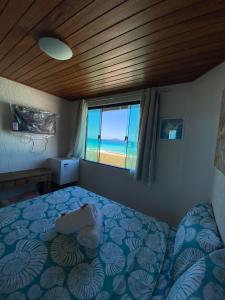 卡波布里奥Pousada Casa do Telhado Verde的一间卧室设有一张床,享有海景