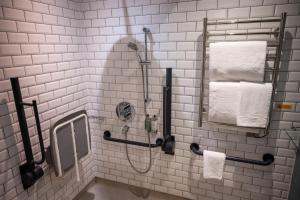 坎伯利Ely Hotel by Chef & Brewer Collection的带淋浴、镜子和毛巾的浴室