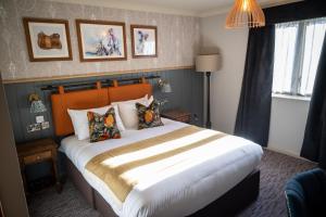 坎伯利Ely Hotel by Chef & Brewer Collection的一间卧室配有一张带枕头的大床