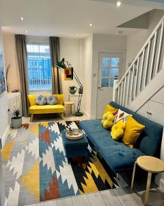 贝尔法斯特Stay-K-Belfast Cosy house 10 mins from city centre的客厅配有蓝色的沙发和黄色的椅子