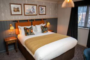 坎伯利Ely Hotel by Chef & Brewer Collection的酒店客房配有一张带枕头的大床