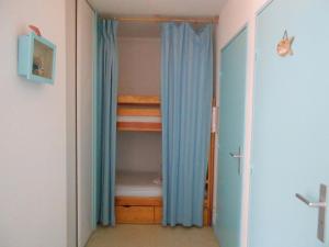 布科·莱斯白老城Appartement Vieux-Boucau-les-Bains, 2 pièces, 5 personnes - FR-1-379-24的一间卧室配有一张双层床和一个带蓝色窗帘的衣柜