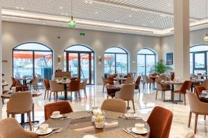 麦纳麦The Grove Resort Bahrain的餐厅设有桌椅和窗户。