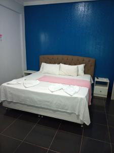 UruaraTopazzo Hotel的一间卧室设有一张蓝色墙壁的大床