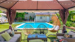 塞维利亚Casa rural cerca de Aracena Castillo de las Guardas by Ruralidays的庭院设有椅子,游泳池前设有秋千。