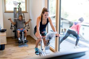 湖城Ferienhaus & Apart Post的一名在健身房骑健身自行车的女子