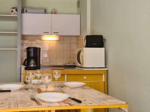 圣拉里苏朗Appartement Saint-Lary-Soulan, 2 pièces, 6 personnes - FR-1-457-253的厨房配有带酒杯的桌子