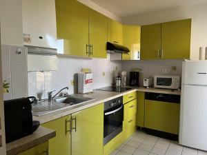 康博莱班Appartement Cambo-les-Bains, 2 pièces, 2 personnes - FR-1-495-74的厨房配有黄色橱柜和白色冰箱