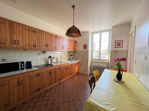 康博莱班Appartement Cambo-les-Bains, 2 pièces, 3 personnes - FR-1-495-79的厨房配有木制橱柜、桌子和窗户。