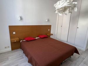 康博莱班Appartement Cambo-les-Bains, 2 pièces, 3 personnes - FR-1-495-79的一间卧室配有一张带两个红色枕头的床