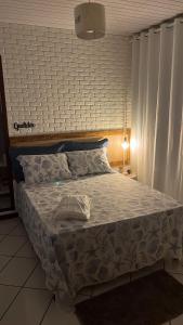 阿拉夏奇巴海滩Luar de Araçatiba Suítes的卧室配有带白色棉被的床