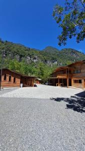 RancoIlli Lodge & Hostel的两个木制建筑前的一个大型停车场