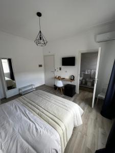 卡塔尼亚Dimora sicula guest house的白色卧室配有一张大床和一张书桌