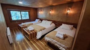 RancoIlli Lodge & Hostel的一间卧室设有三张床和窗户。