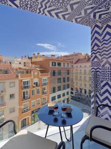 马拉加H10 Croma Málaga的阳台上的桌子和两杯葡萄酒
