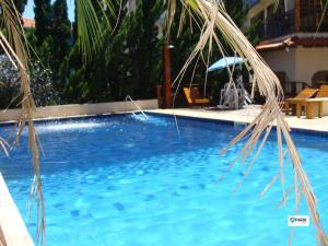 圣罗克São Roque Park Hotel的蓝色游泳池配有遮阳伞和椅子