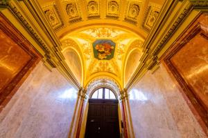 布达佩斯Adagio Downtown Rooms的一条带金色天花板和门的走廊