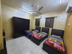亚喀巴العاصم للشقق الفندقية ALASEM HOTEL APARTMENTS的客房设有两张床和吊扇。