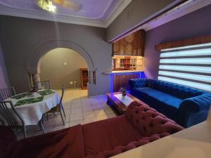 博克斯堡La-Nuel Guest Lodge的客厅配有桌子和蓝色沙发