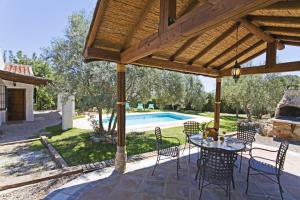 埃尔乔罗Villa La Clavelina Rocabella的一个带桌椅的庭院和一个游泳池