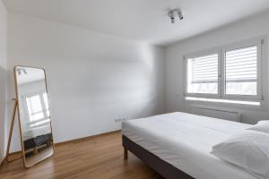 博洛尼亚Casa Bassani con terrazzo by Wonderful Italy的白色卧室配有床和镜子