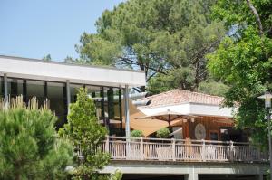 卡普费雷Domaine du Ferret Restaurant & Spa的带阳台的房屋,配有遮阳伞